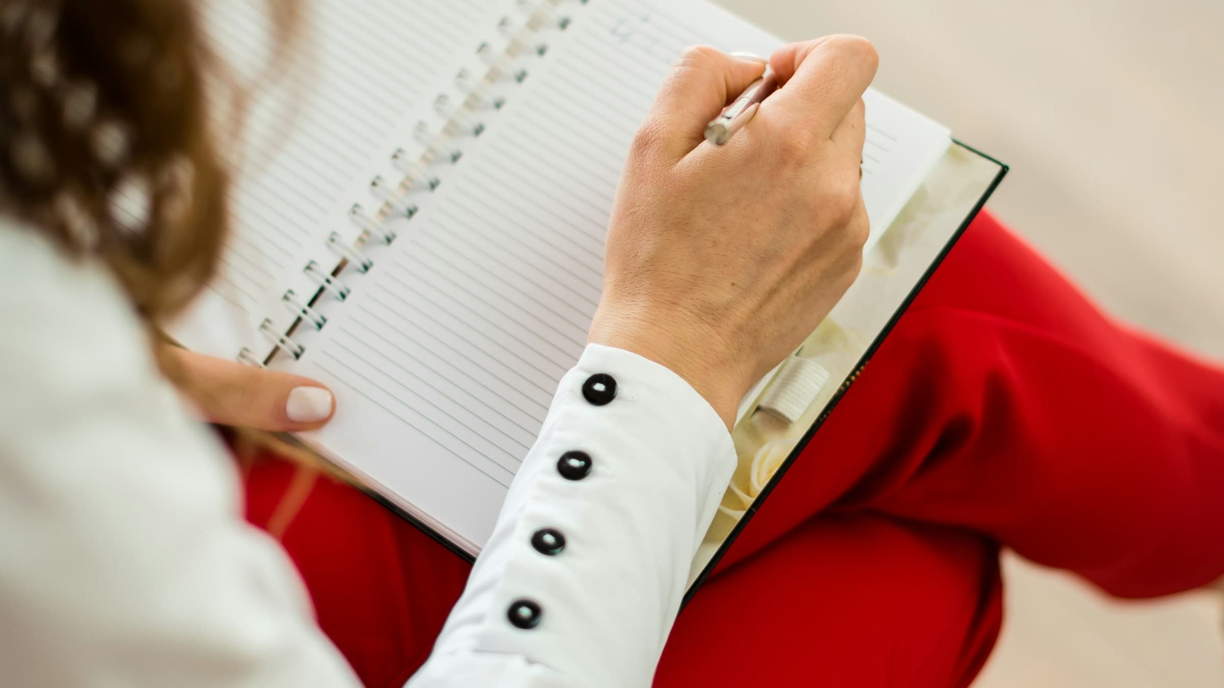 Hands writing in a notebook